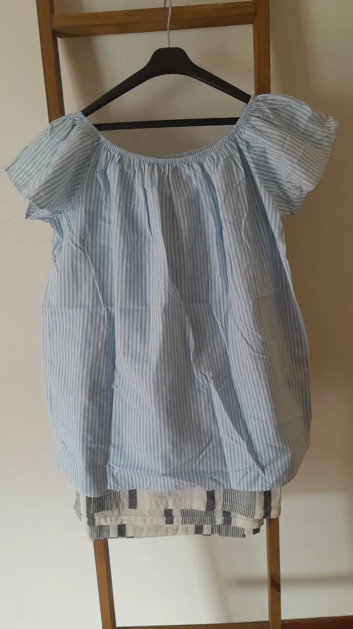 Remera a rayas celeste y blanca, con escote Bardot y mangas cortas con volados. Ideal para un look fresco y casual de verano.