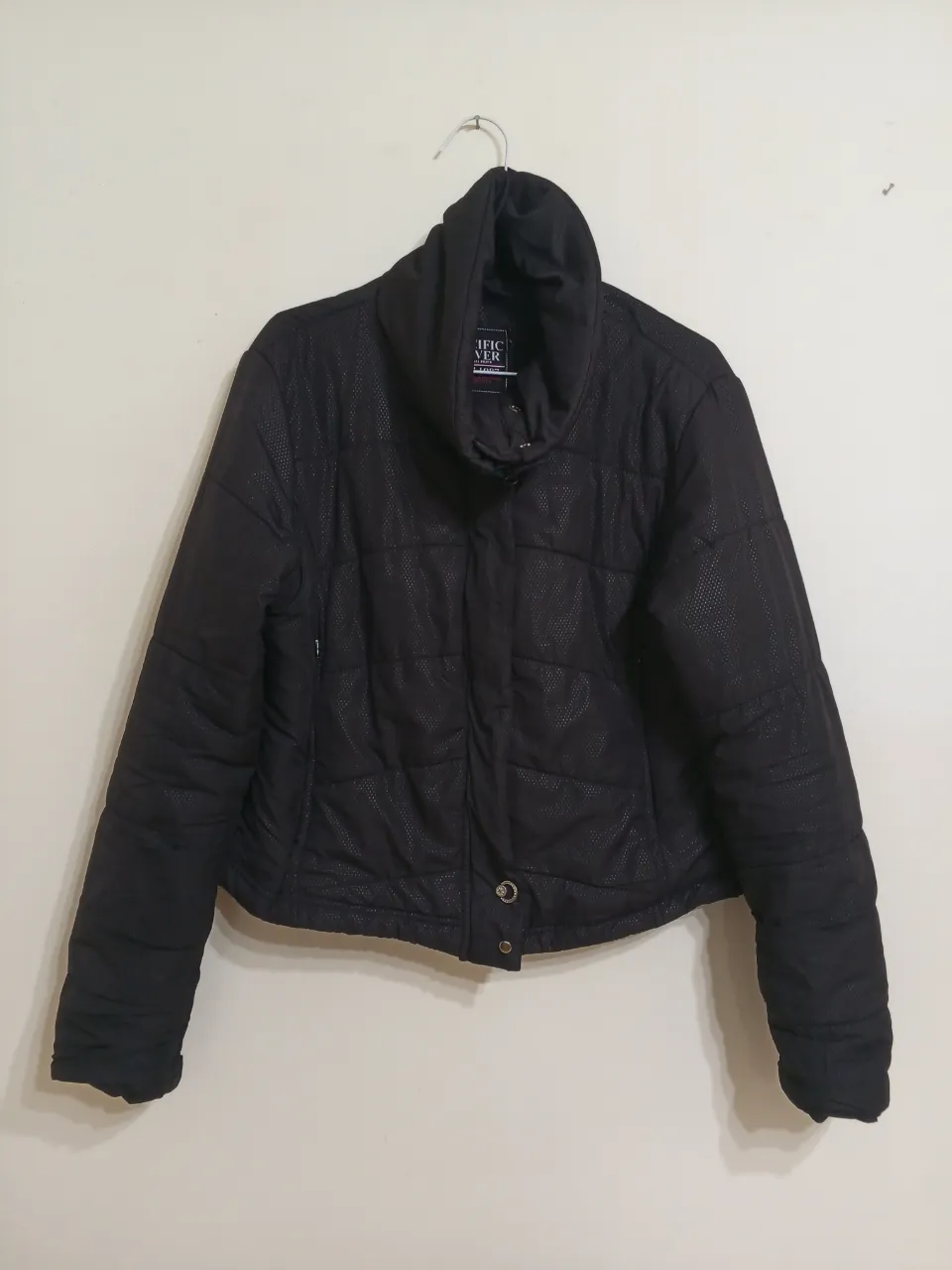 Campera Pacific Silver negra, con cuello alto y botones decorativos. Diseño acolchado con textura. Ideal para el invierno.