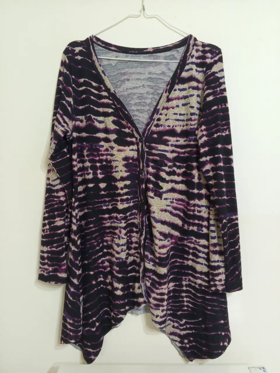 Cardigan largo con estampado abstracto en tonos violeta y negro. Corte asimétrico y escote en V. Ideal para un look casual y moderno.