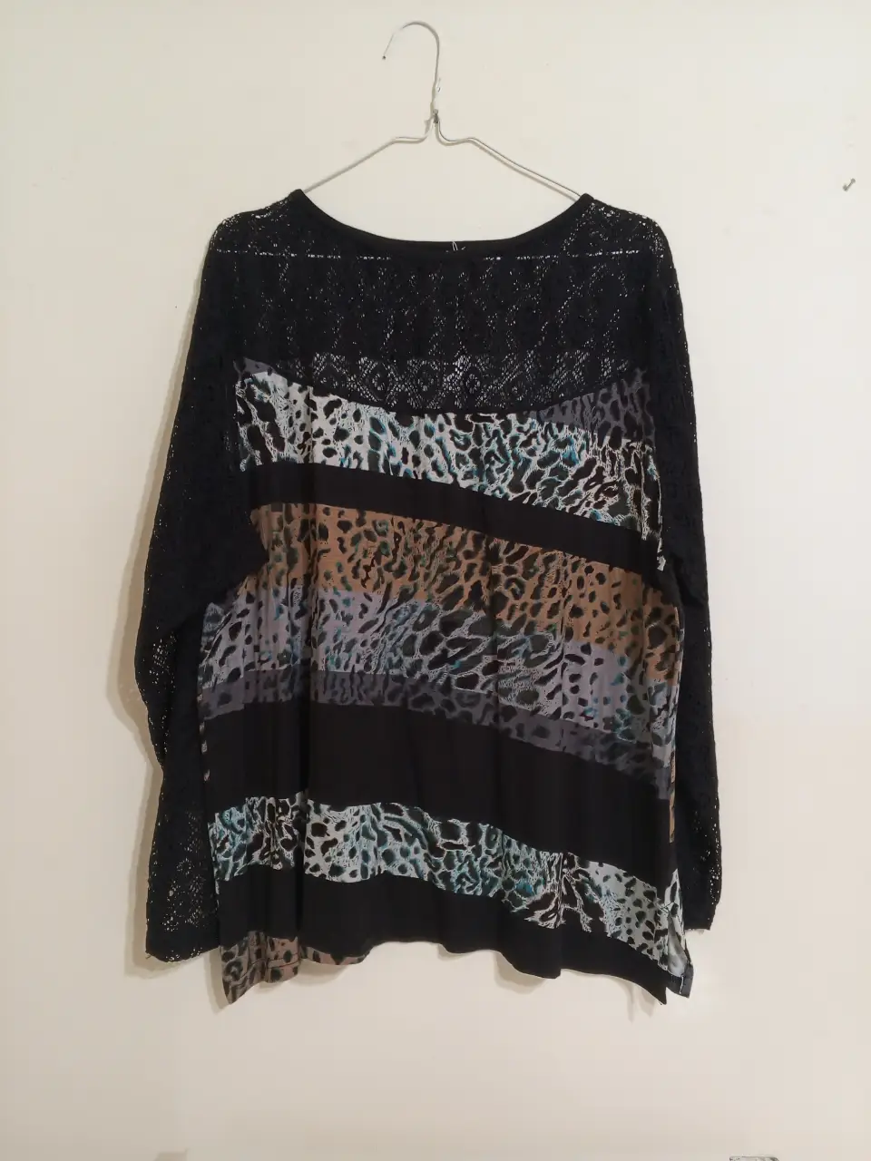 Blusa de manga larga con detalles de encaje y estampado animal print. Ideal para un look elegante y moderno.