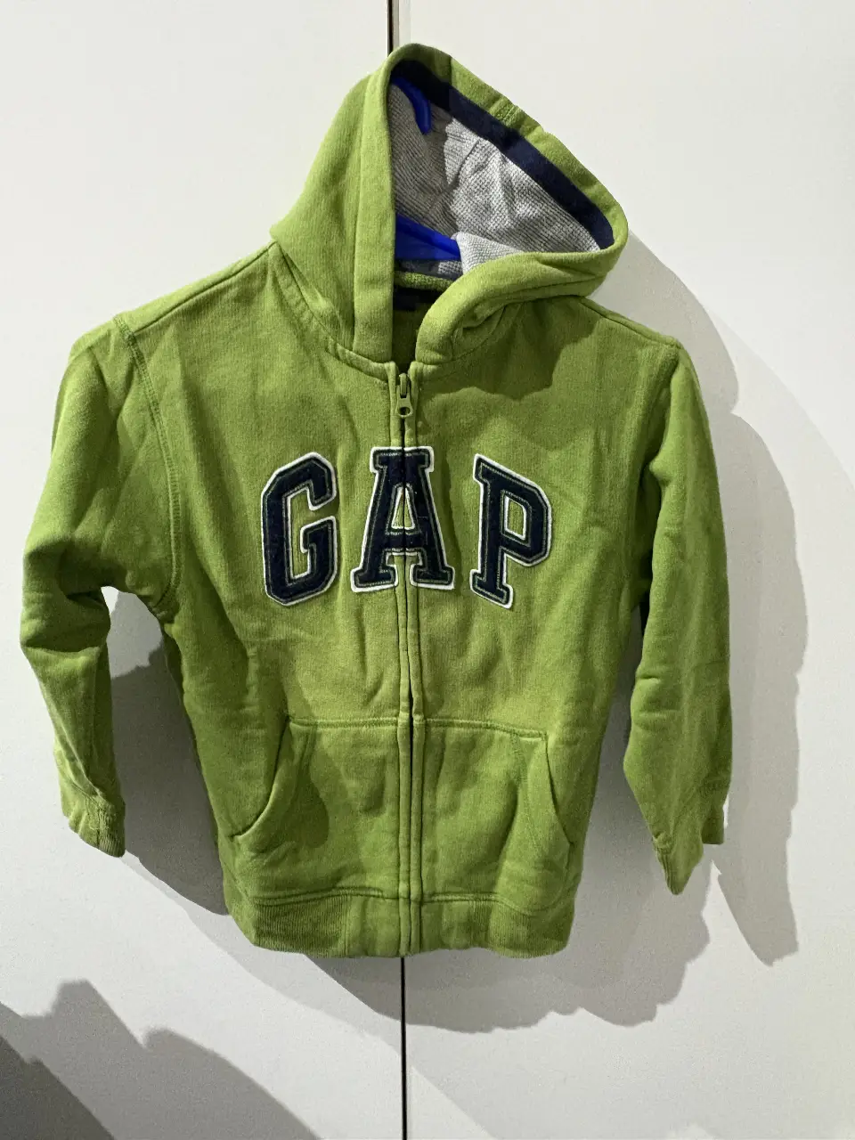 Buzo con cierre para niño, color verde con el logo GAP en el frente. Talle S (6-7). Ideal para uso casual.
