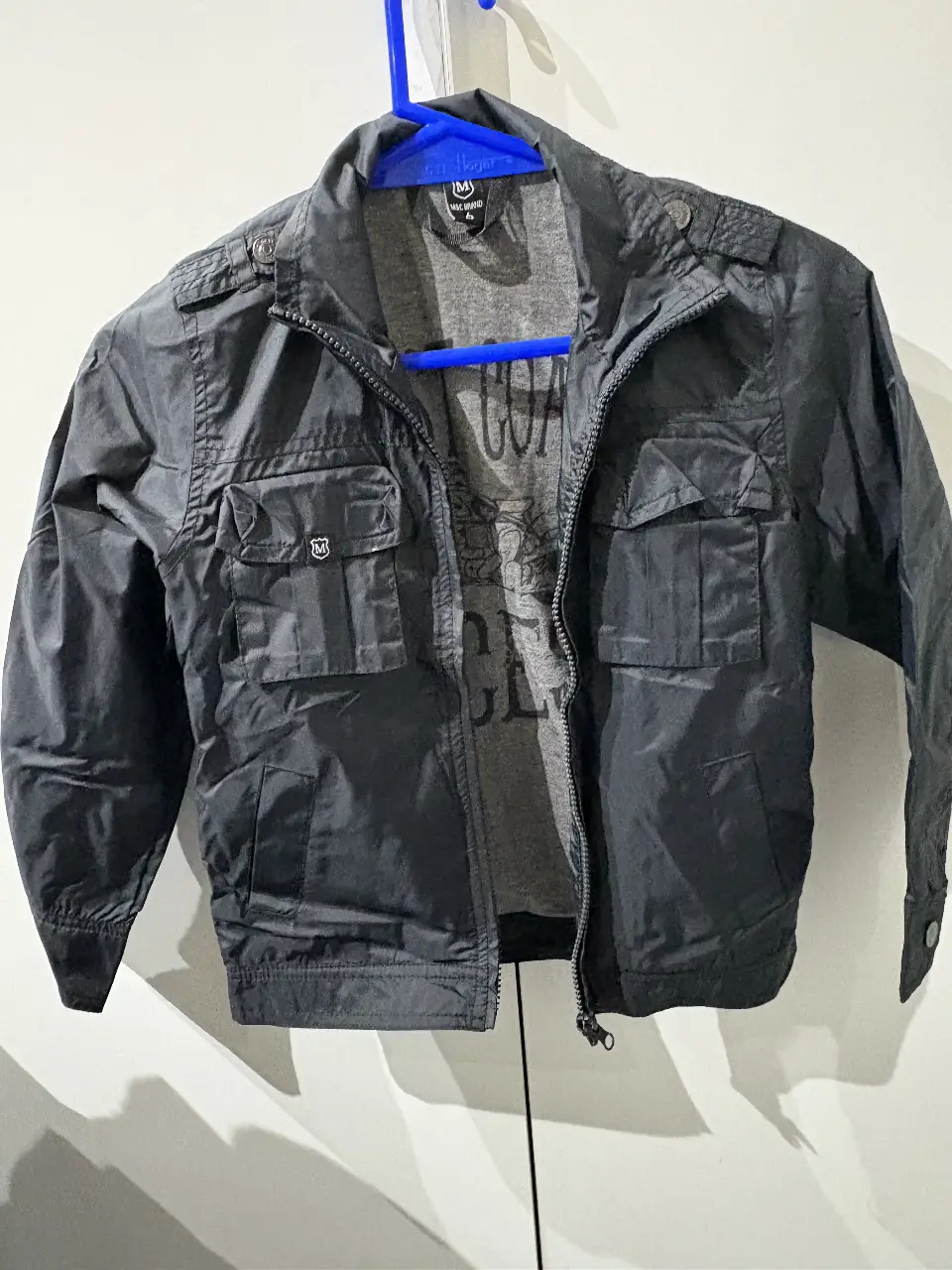 Campera negra para niño, con cierre y bolsillos. Interior con estampa de "West Coast Aces". Ideal para un look casual y canchero.