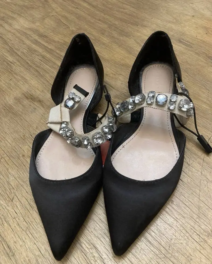 Elegantes sandalias de mujer en color negro, con detalles de pedrería en la tira del empeine y un diseño de punta fina. Perfectas para eventos formales o para darle un toque sofisticado a cualquier look.