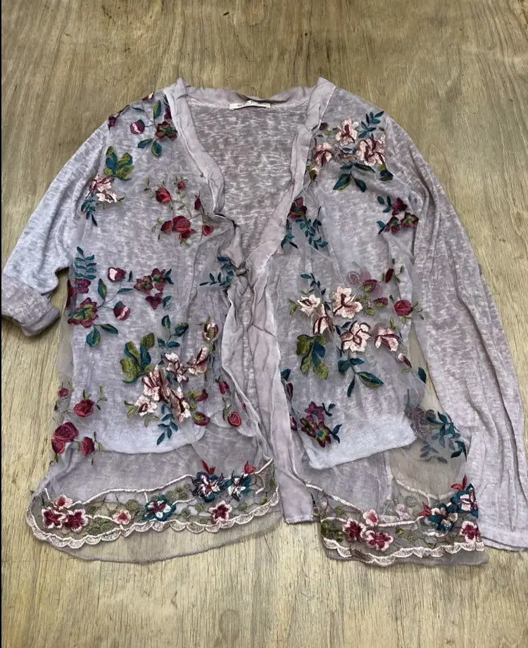 Cárdigan de mujer con bordados florales en tul. Manga larga con botón en puño. Marca Emma.
