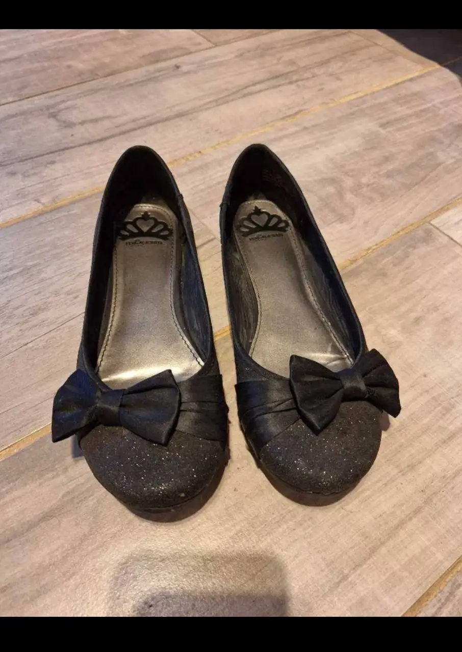 Ballerinas negras con moño y brillos, ideales para fiesta o eventos especiales. Diseño elegante y cómodo.