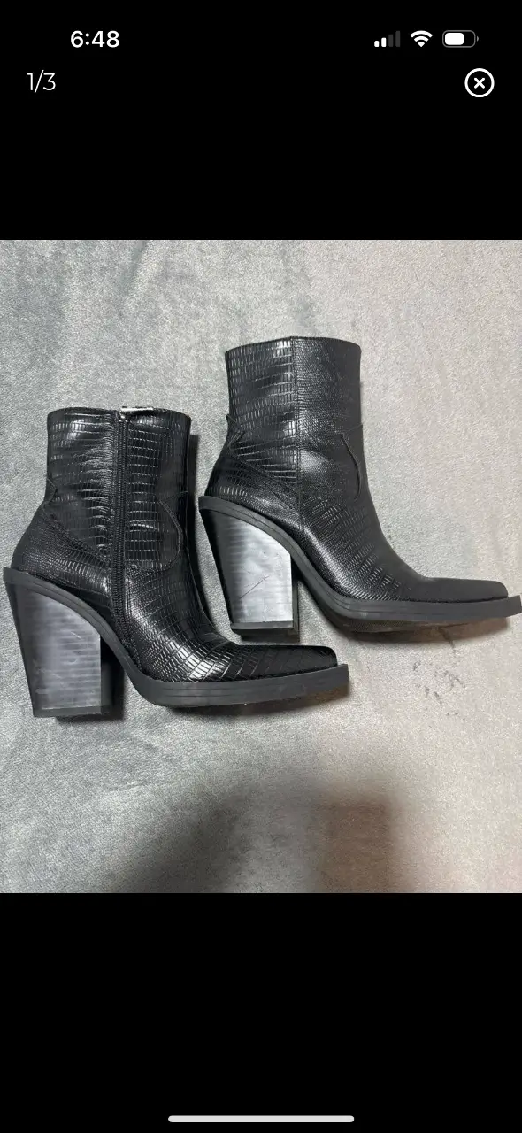 Botines de cuero negro con textura de reptil, taco ancho y cierre lateral. Ideales para un look moderno y sofisticado.