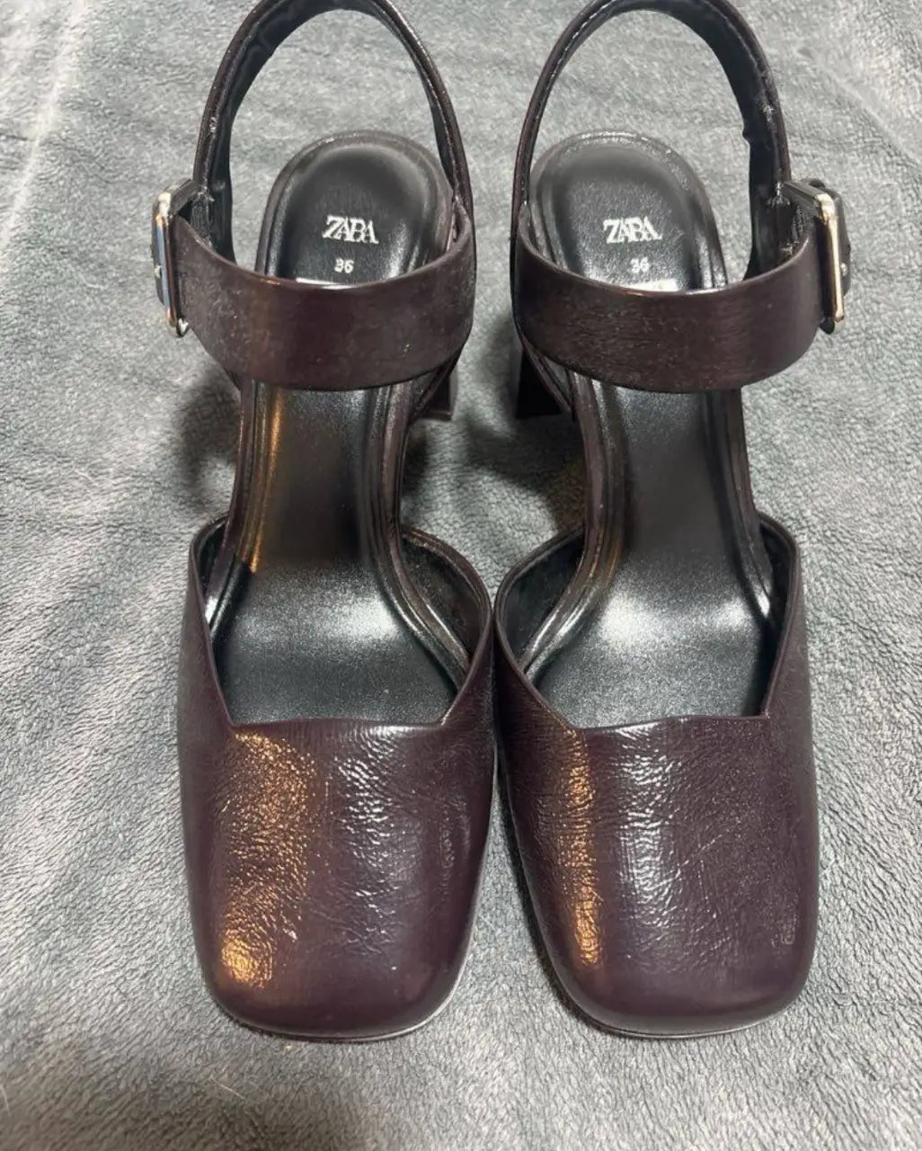 Sandalias de taco alto color marrón oscuro de la marca Zara. Tienen un diseño elegante con pulsera en el tobillo y punta cuadrada. Ideales para completar un look sofisticado.