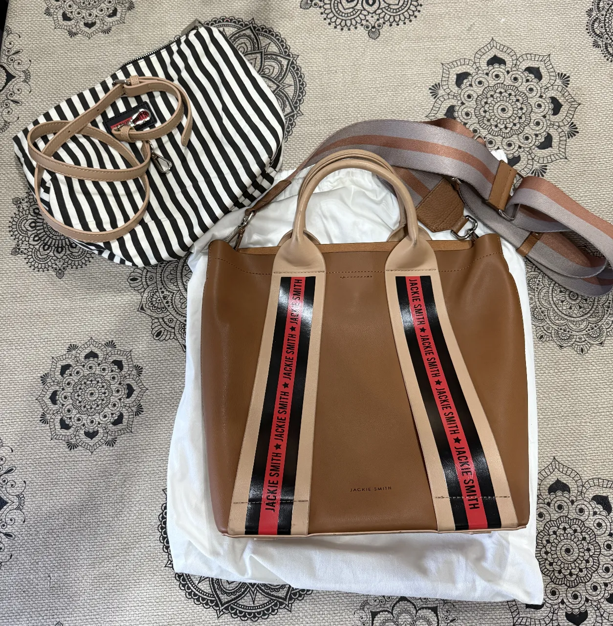 Bolso tote de cuero marrón con detalles en beige y negro. Diseño Jackie Smith con correas a rayas y correa larga ajustable. Ideal para uso diario y con estilo.