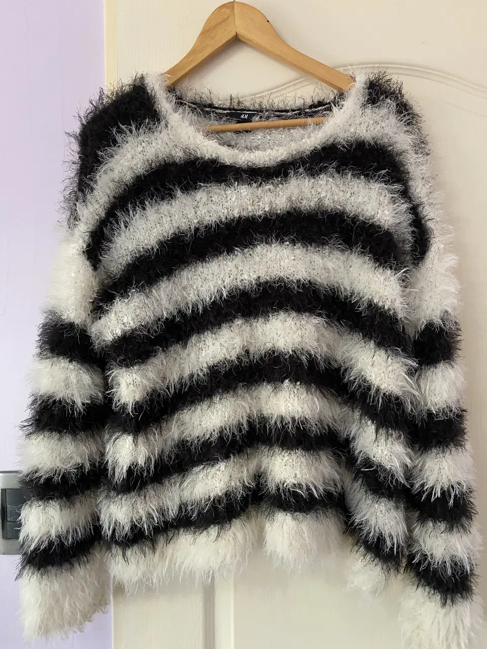 Sweater de mujer a rayas horizontales en blanco y negro, con un diseño peludo y textura suave. Ideal para un look casual y abrigado.