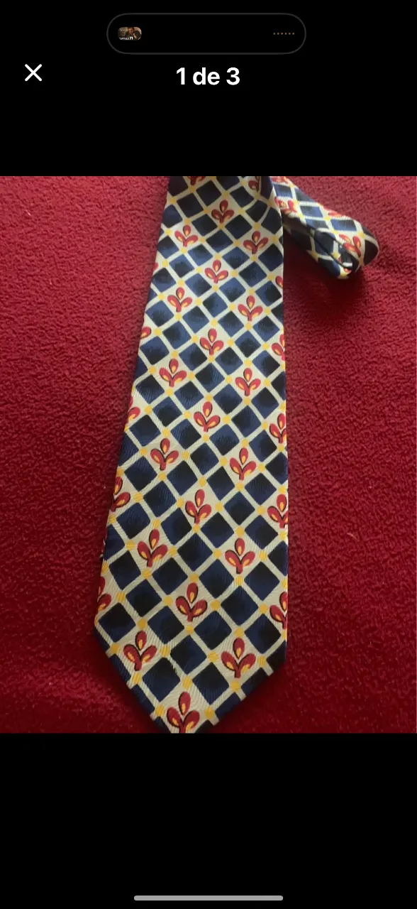 Corbata de vestir con un estampado de rombos en azul marino, blanco y detalles en rojo y amarillo. Perfecta para darle un toque de color y elegancia a tu look formal o de trabajo. Giesso