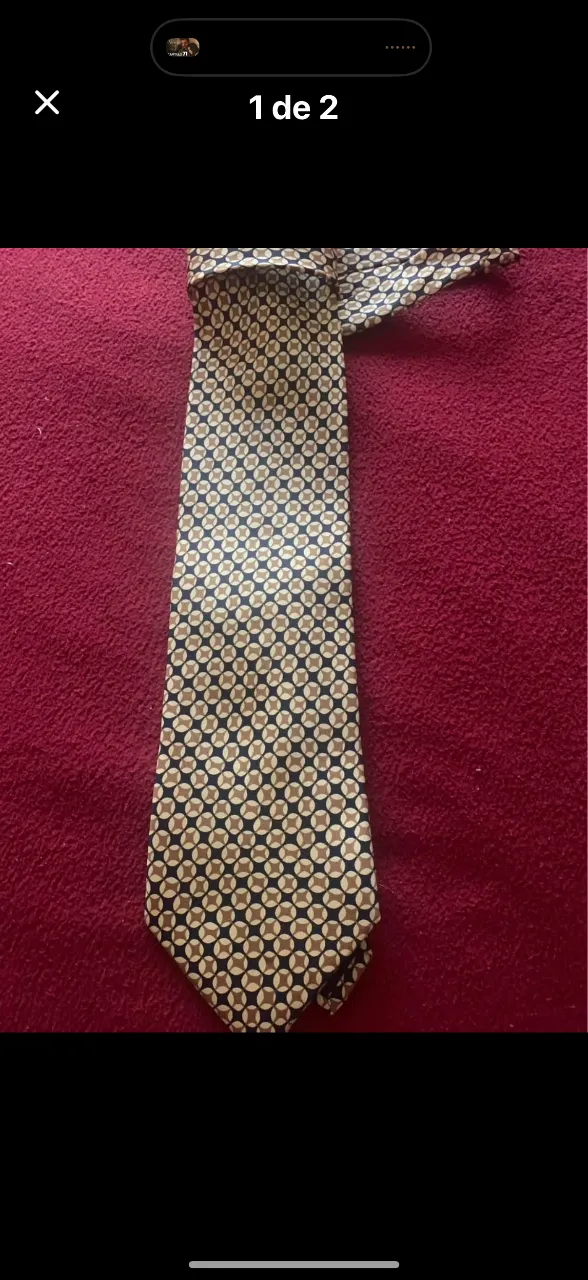 Corbata de vestir con un estampado geométrico de círculos concéntricos en tonos beige y azul marino. Perfecta para complementar un look formal o de trabajo.