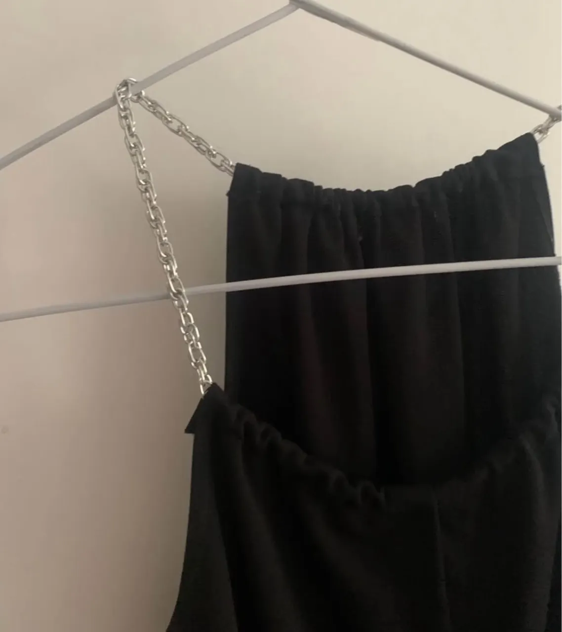 Vestido negro con tirantes de cadena plateada. Ideal para eventos formales o salidas nocturnas. Diseño elegante y moderno.talle M largo 96 cm con esvote americano regulable .. crepe con spandex adaptable al cuerpo.