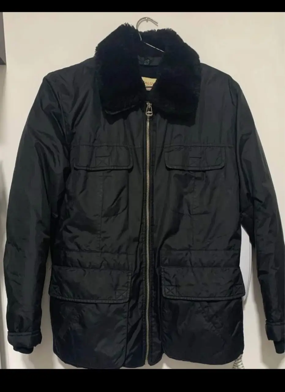 Campera negra con cuello de piel sintética, cierre frontal y bolsillos. Ideal para el invierno, estilo casual y utilitario. relleno de plumas.. super calentita.. 