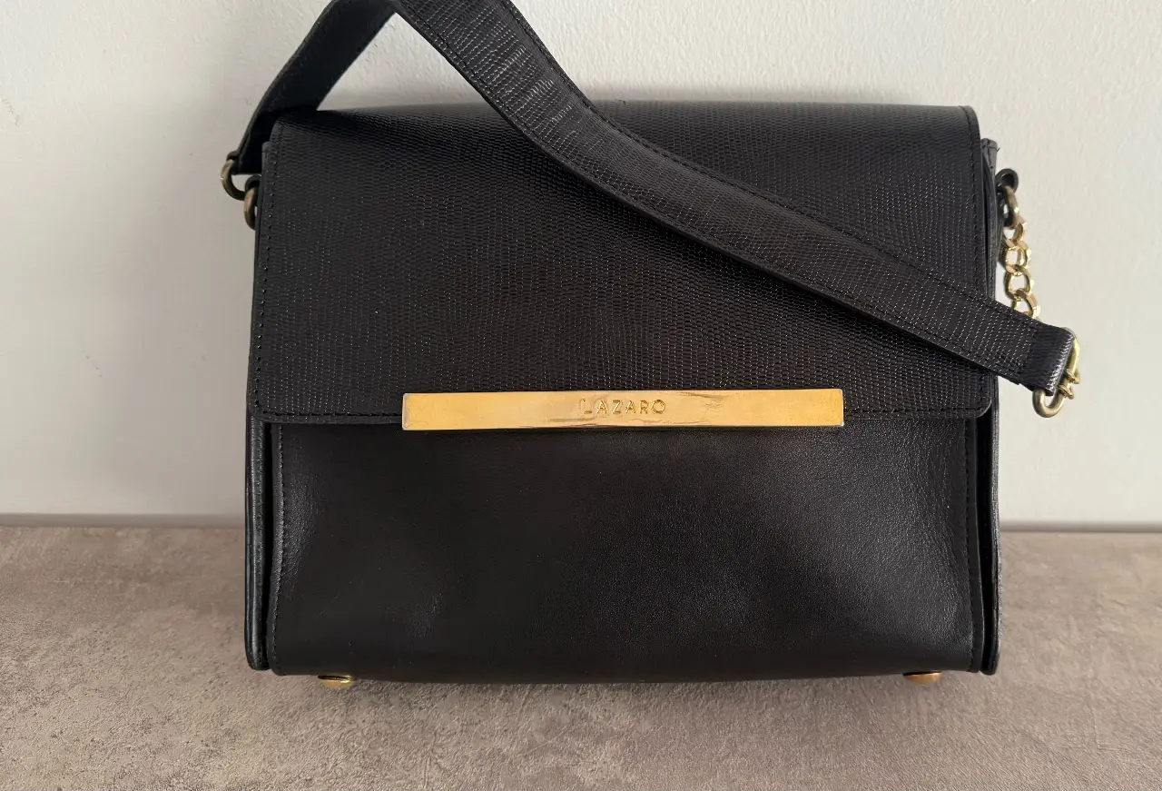 Cartera Lazaro de cuero negro combinado, con detalles  Cuenta con un compartimento principal y un bolsillo interno con cierre. Perfecta para cualquier ocasión.  un solo uso. Impecable!!