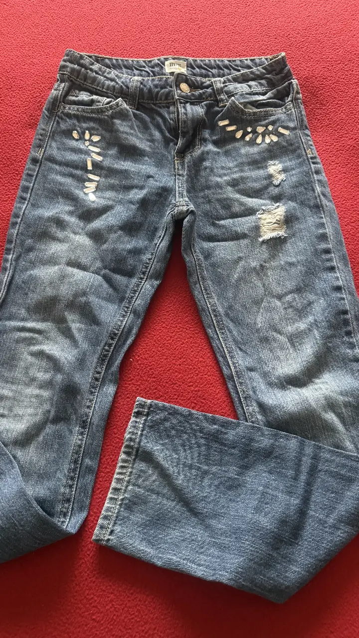 Jeans de niña ,con detalles de apliques brillantes y roturas. Un clásico renovado para un look canchero y moderno. un solo uso