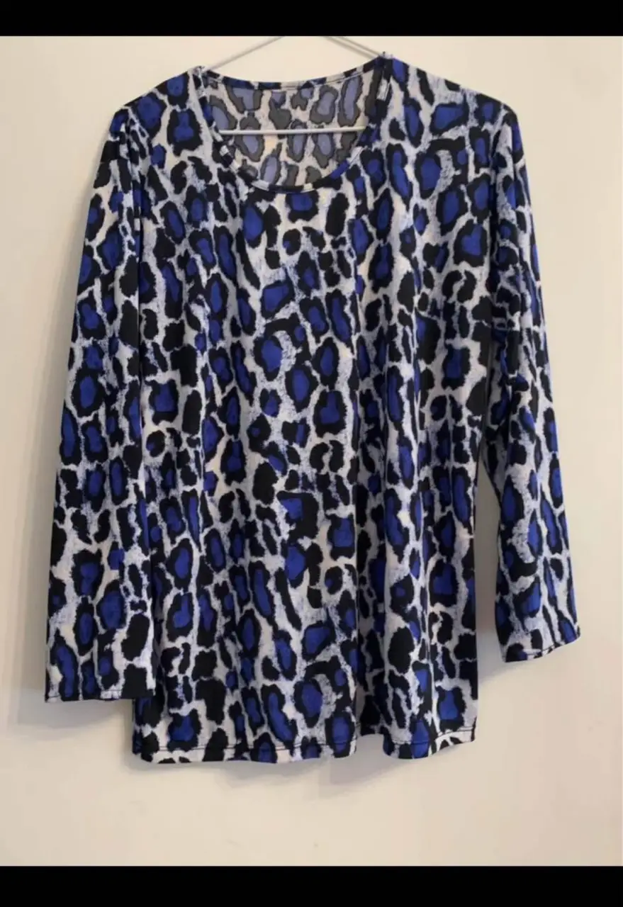 Blusa de mujer con estampado de leopardo en tonos azul y blanco. Manga larga y cuello redondo. Ideal para un look casual y moderno.