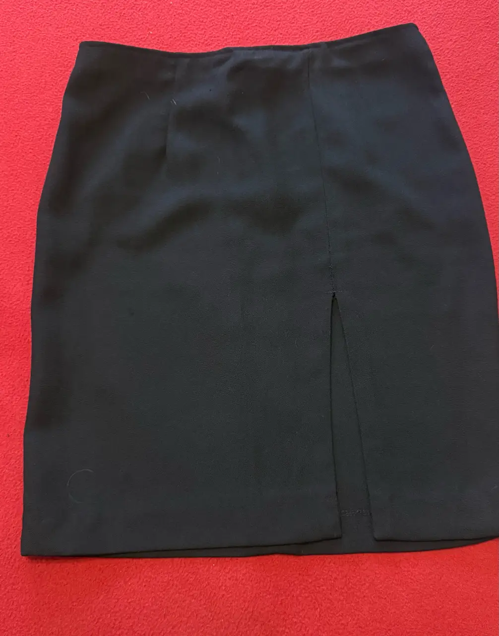 Minifalda negra con abertura frontal, ideal para un look casual. crepe talle 40