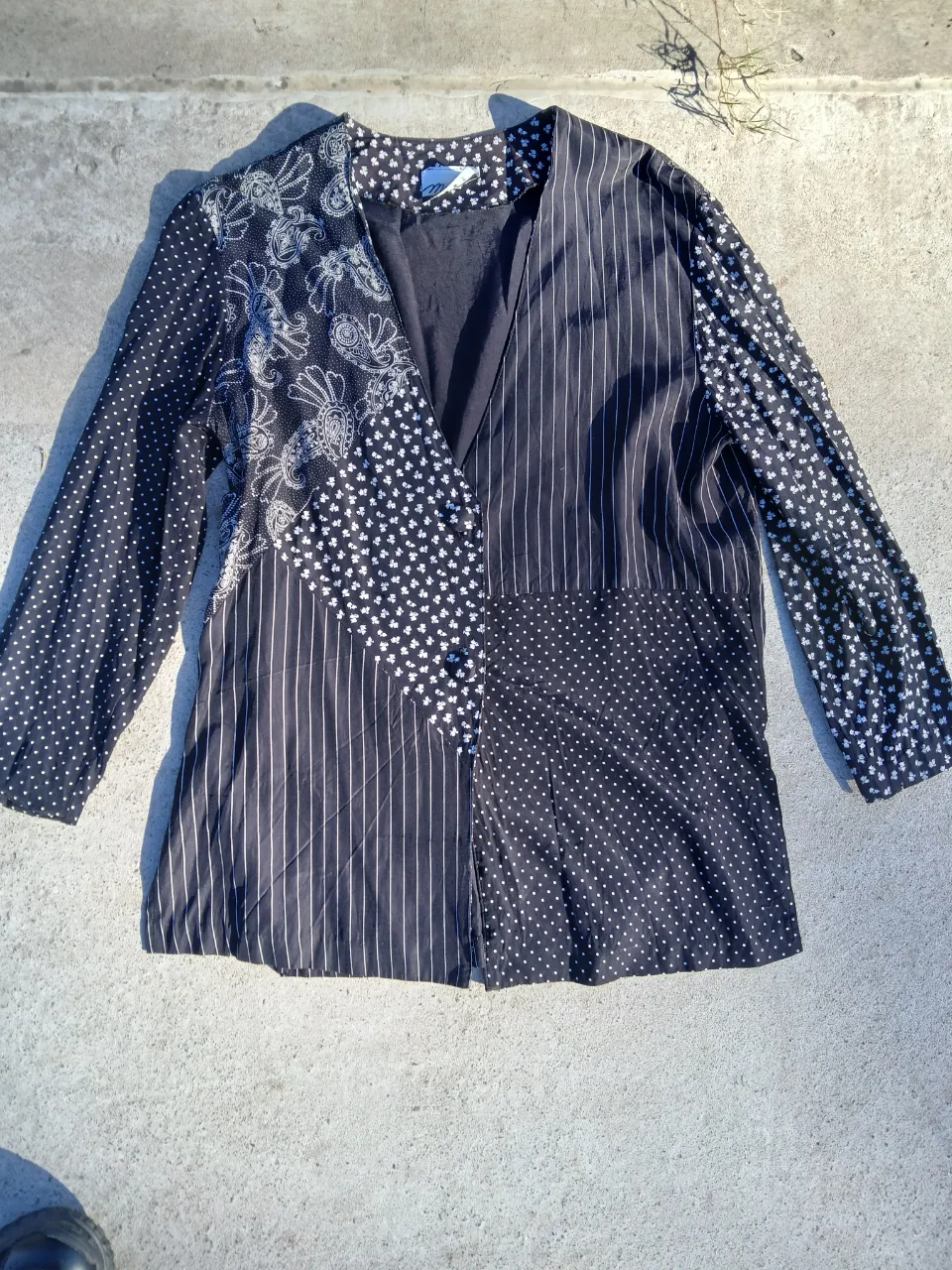 Blazer de diseño patchwork en blanco y negro. Confeccionado con diferentes estampados y texturas, incluyendo lunares, flores y rayas. Ideal para un look vintage y original.