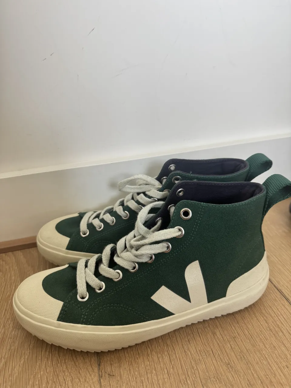 Zapatillas de lona altas color verde oscuro con detalles en blanco y suela blanca.