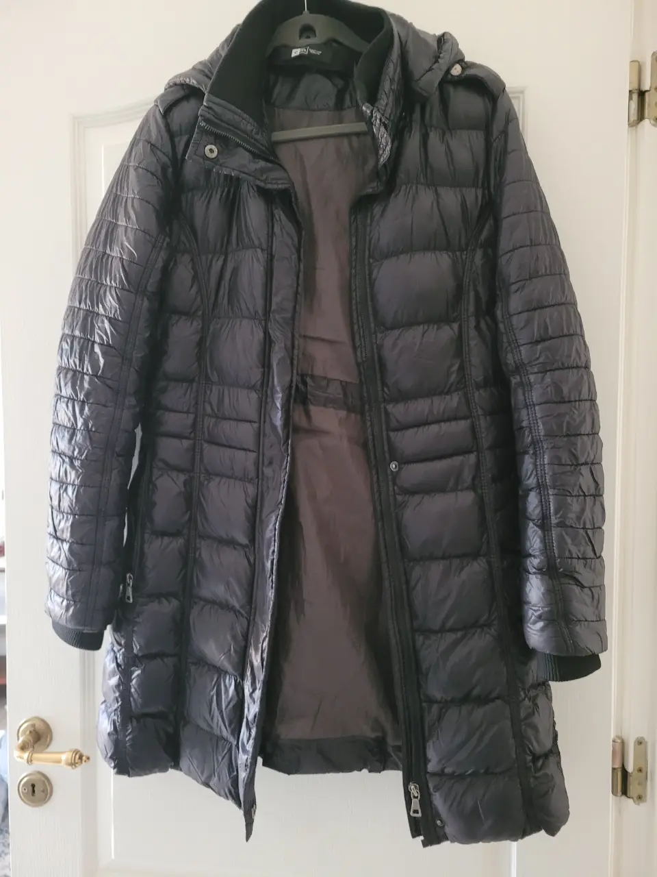 Campera de pluma negra larga con capucha, ideal para el invierno. Marca Rip Curl, talle Large.