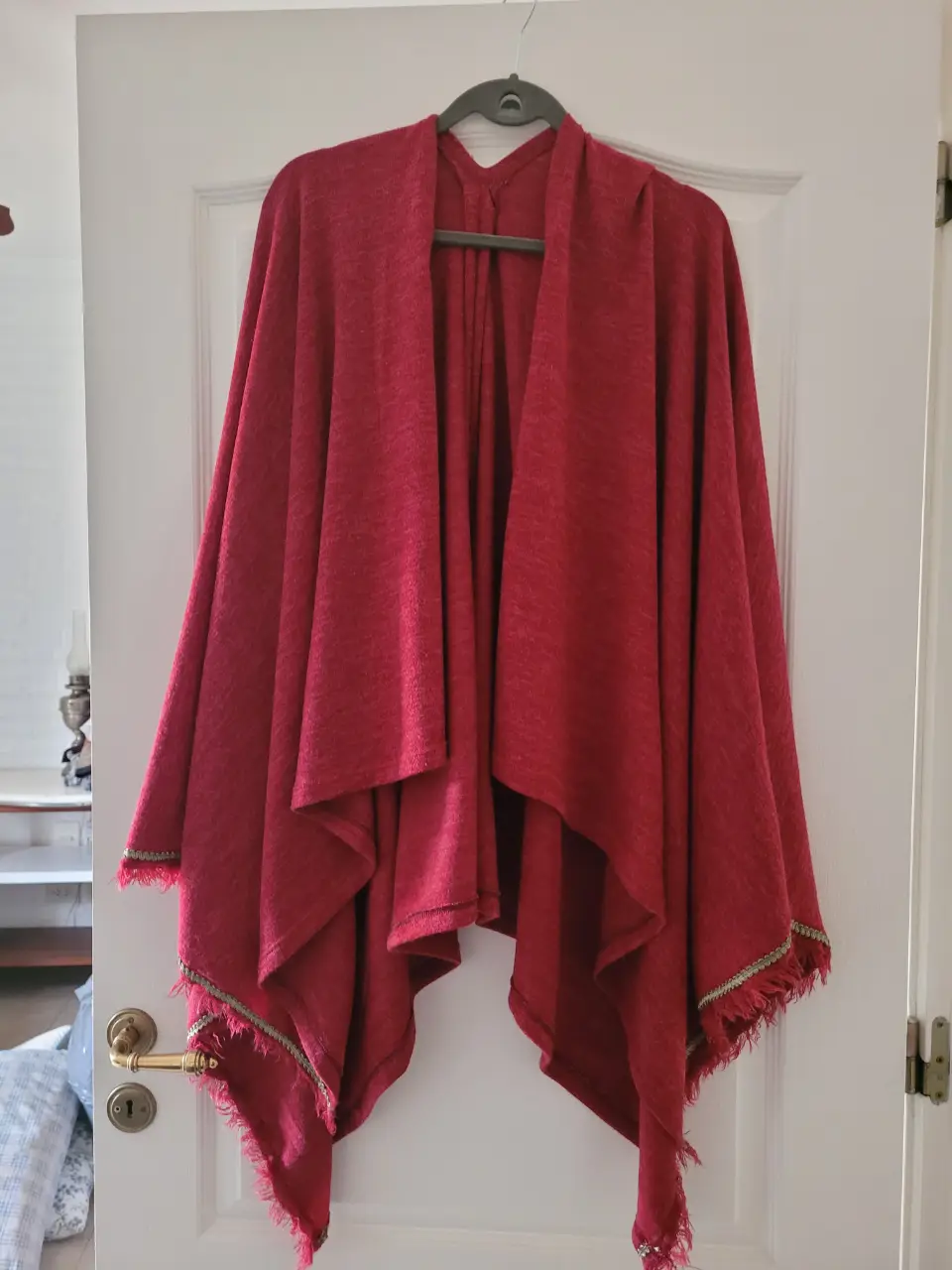Precioso poncho bordo con detalles de flecos y bordes dorados. Ideal para un look bohemio y abrigado en otoño/invierno. Perfecto para salidas casuales o eventos especiales.
