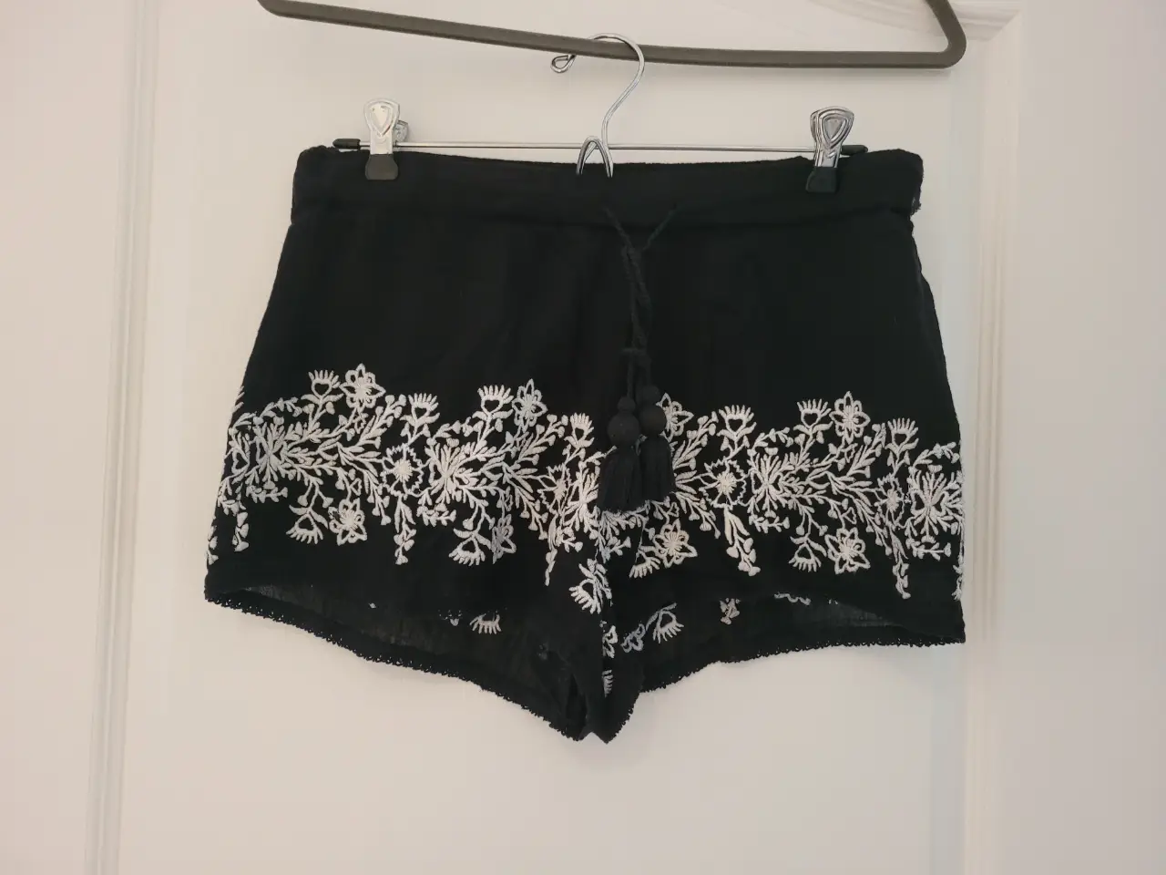 Shorts negros de tela con bordado floral blanco en el borde inferior. Talle M, de la marca Trafaluc collection de Zara