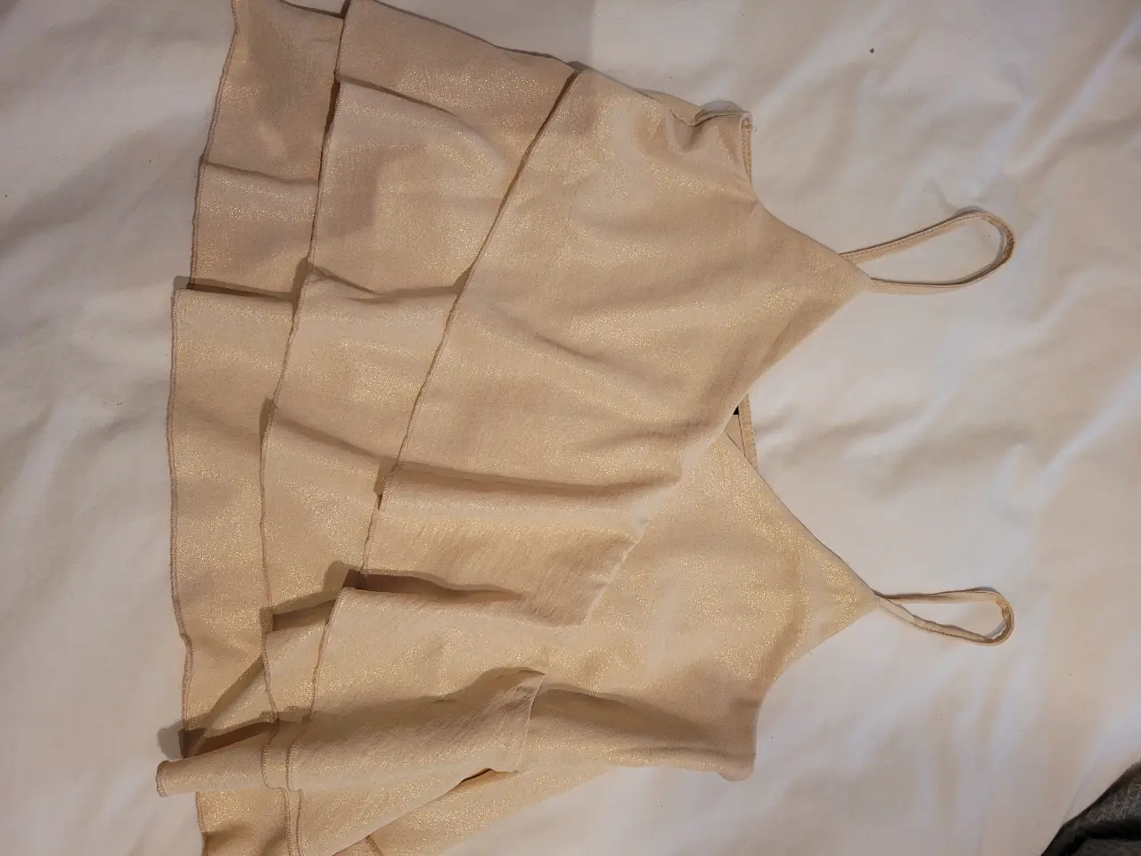 Top de mujer con diseño de volantes y tirantes finos. Ideal para eventos especiales o salidas nocturnas. Talle L. Dorado