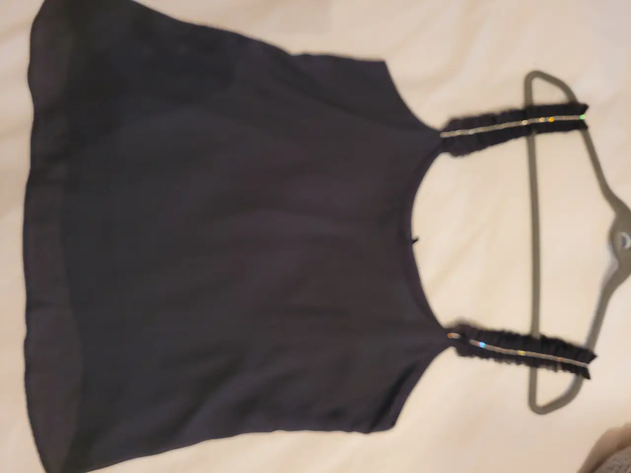 Top negro con detalles de brillos en los breteles. Ideal para una salida nocturna o evento especial. Talle L.