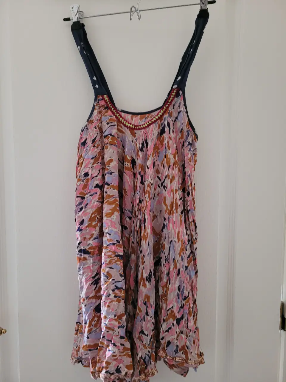 Vestido/remeron midi de tela fluida con estampado abstracto en tonos rosas, marrones y lilas. Detalles de bordado en el escote y tirantes en azul marino. Ideal para un look bohemio y fresco. Marca holi de dolores barreiro