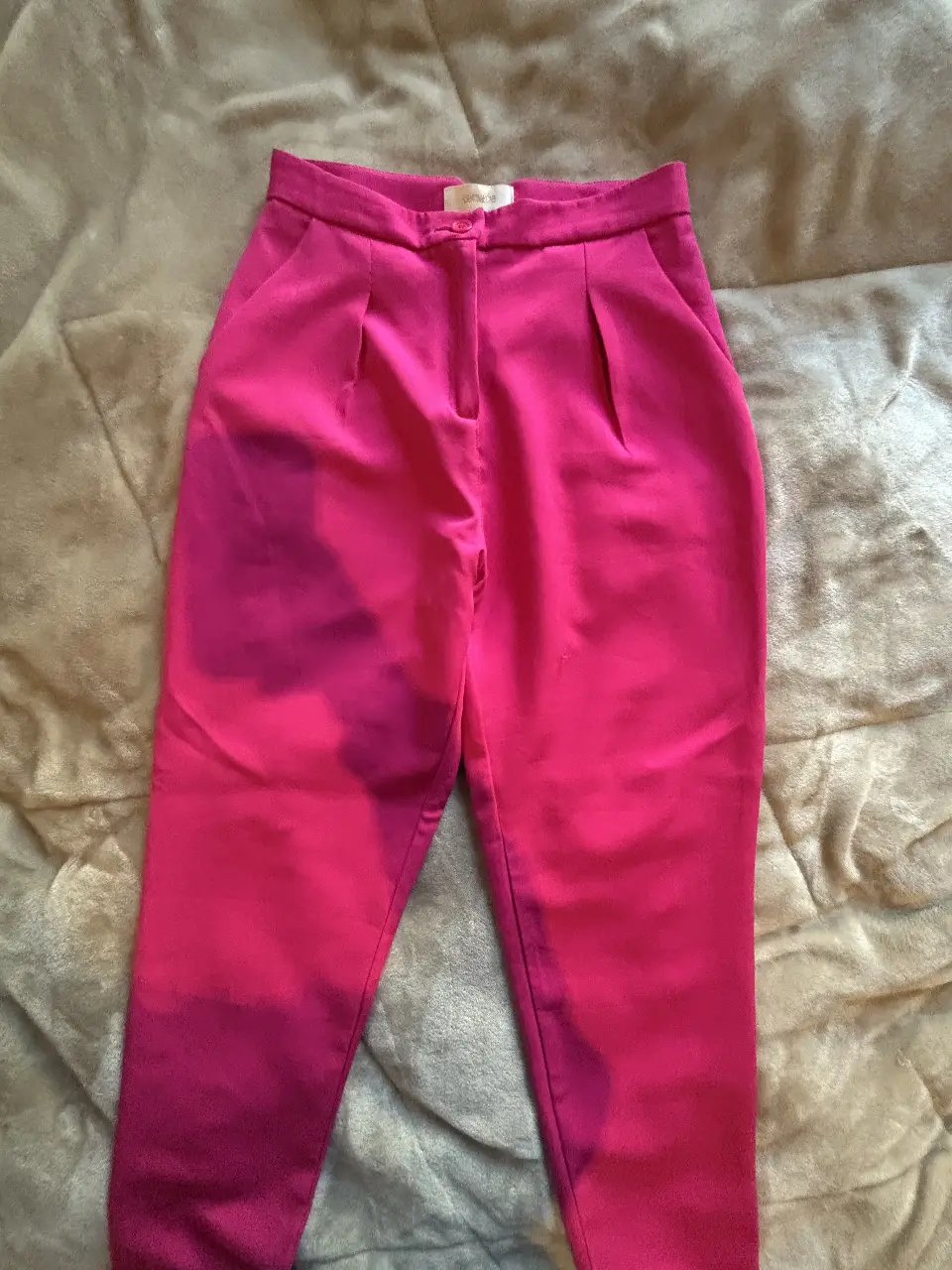 Pantalón sastrero fucsia de tiro alto, con pinzas delanteras y bolsillos traseros. Ideal para un look elegante y moderno.