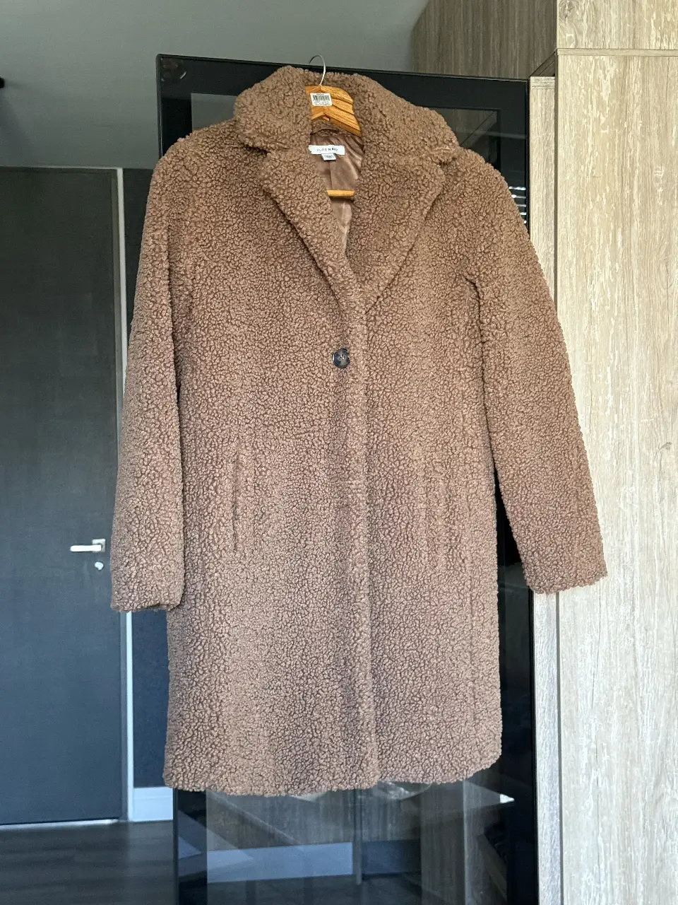 Tapado largo de mujer, color marrón, estilo teddy, con cuello solapa y un botón. Ideal para el invierno.
