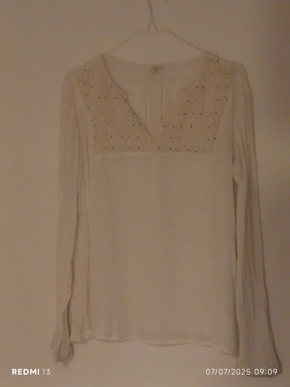 Blusa blanca con detalle bordado en el pecho. Manga larga y cuello en V. Ideal para un look casual y elegante.