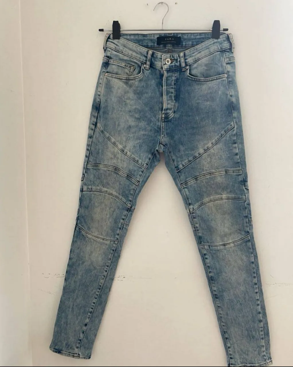 Jeans de hombre de la marca Zara, (importado) con diseño de lavado claro y detalles en las rodillas. Corte recto y cierre con botones.