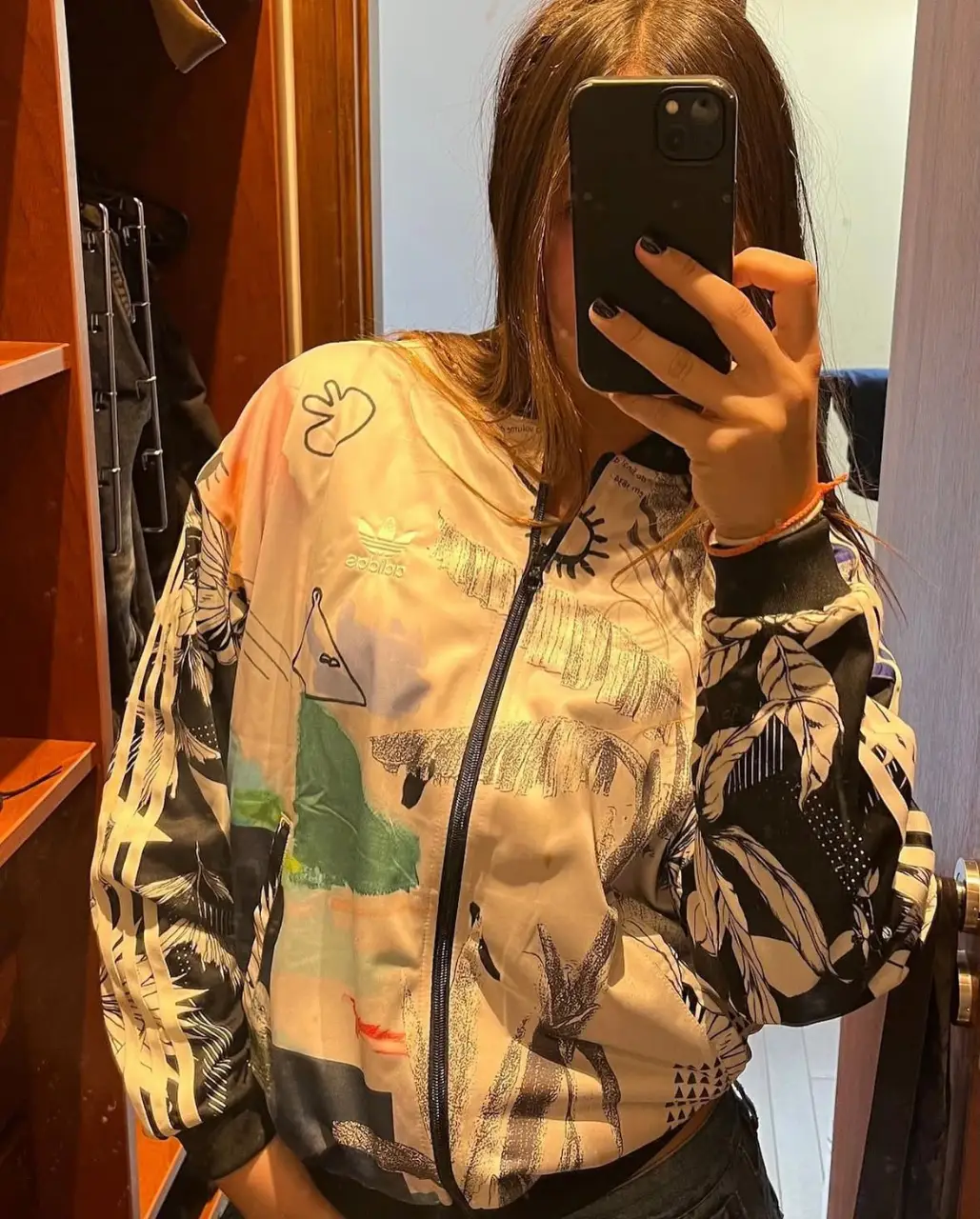 Campera bomber Adidas con estampado floral y detalles de diseño. Posee cierre frontal y puños elastizados. Ideal para un look casual y moderno.