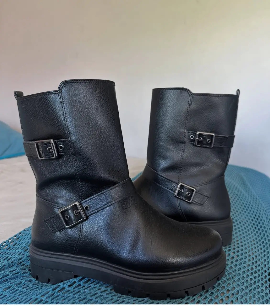 Botas negras de cuero sintético con detalles de hebillas y suela gruesa. Ideales para un look moderno y urbano.