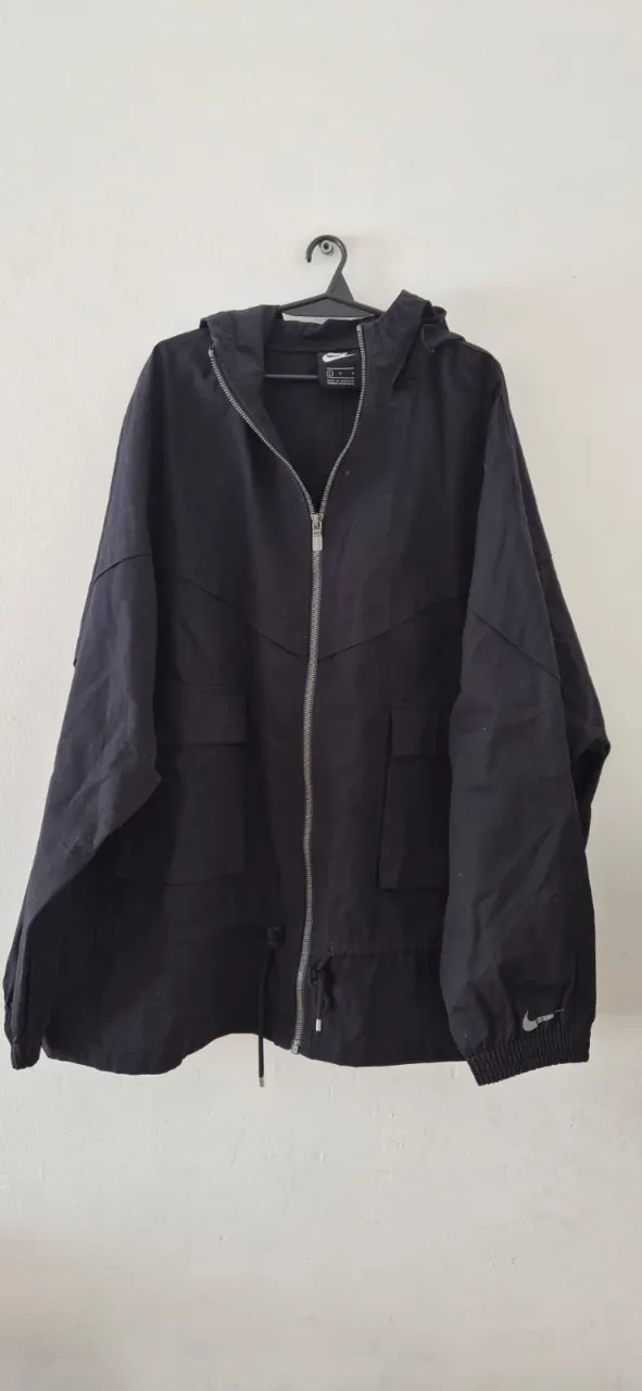 Campera negra con capucha, ideal para entretiempo. Posee bolsillos frontales y cierre completo. Un básico versátil para tu guardarropa.