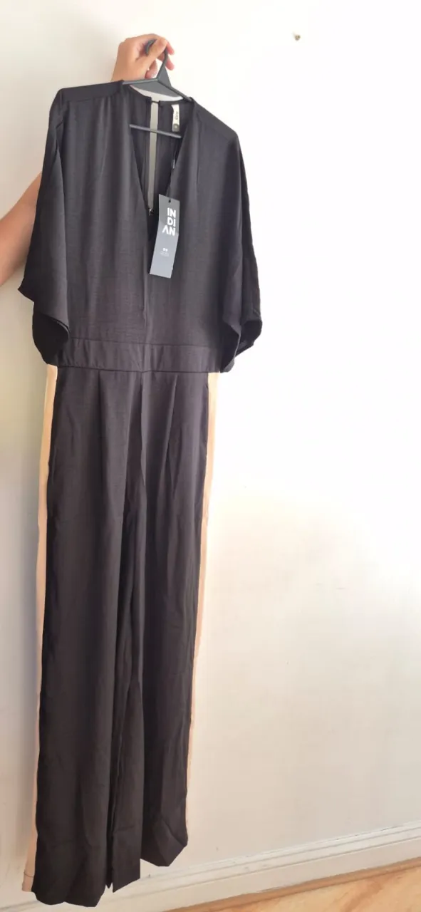 Mono largo negro con detalles en los laterales color crudo. Posee escote en V y mangas cortas tipo murciélago. Ideal para un look elegante y moderno.