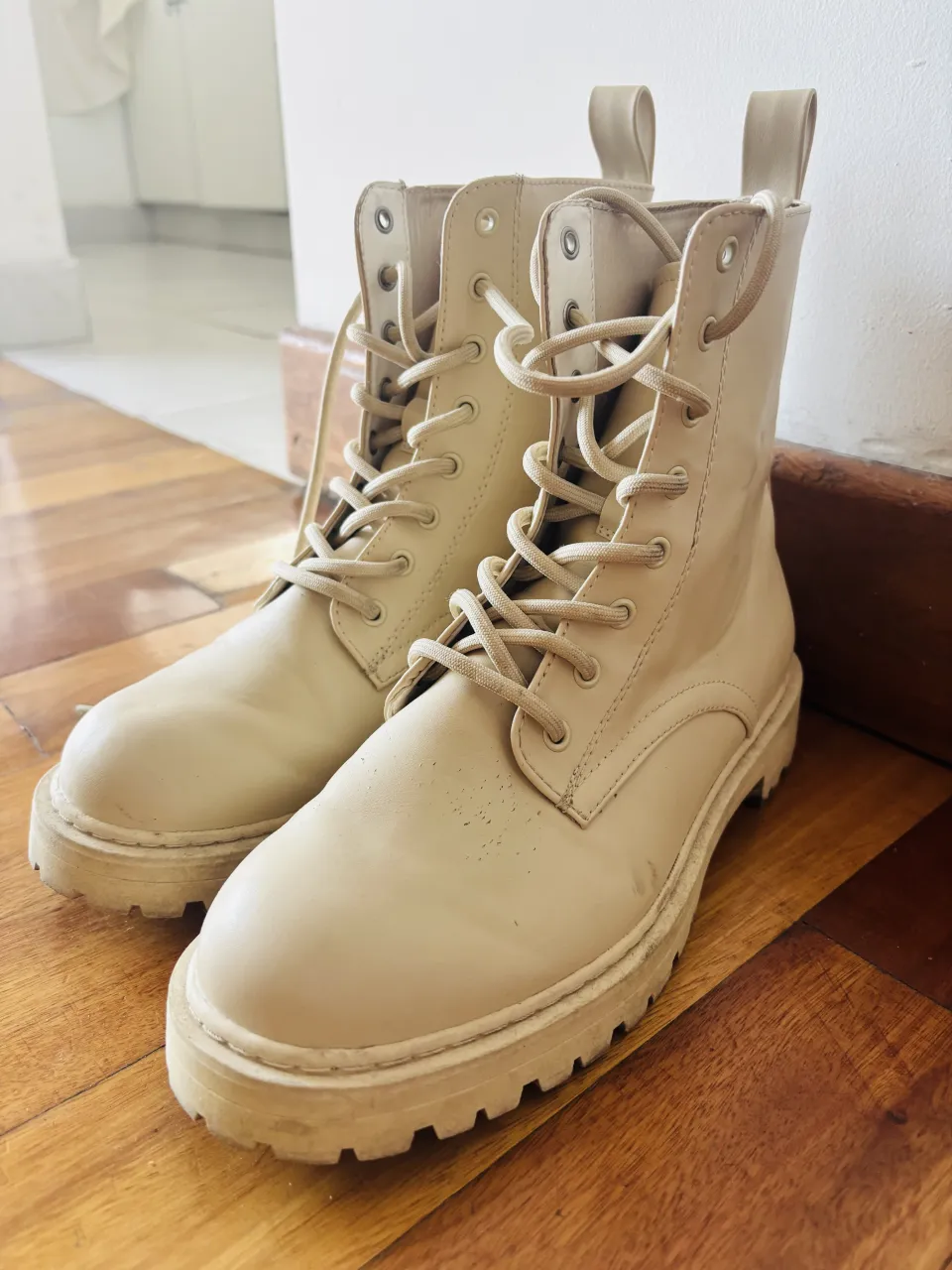 Botas de cuero color crudo con cordones y suela track.