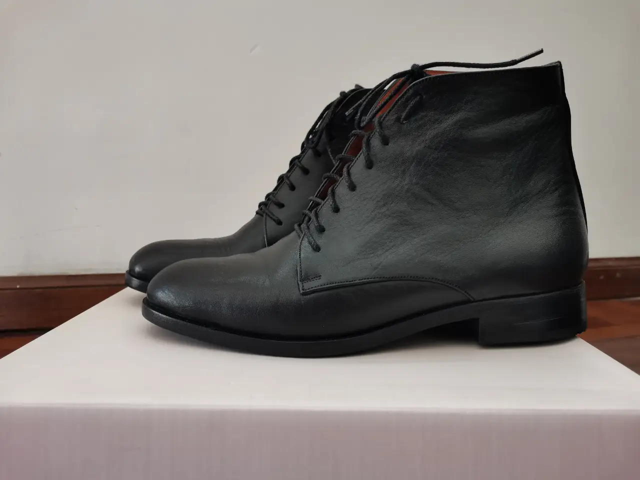 Botines de cuero negro para mujer, con cordones y diseño elegante. Ideales para un look sofisticado y versátil.