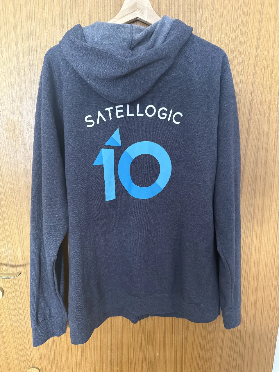 Buzo conmemorativo de Satellogic por los 10 años de la empresa

Buzo con capucha y cierre completo, ideal para un look casual y cómodo. Presenta un diseño estampado en la espalda con el logo 'SATELLOGIC' y un número '10' en tonos azules, mientras que en el frente tiene un pequeño texto 'NOW YOU SEE'. 
