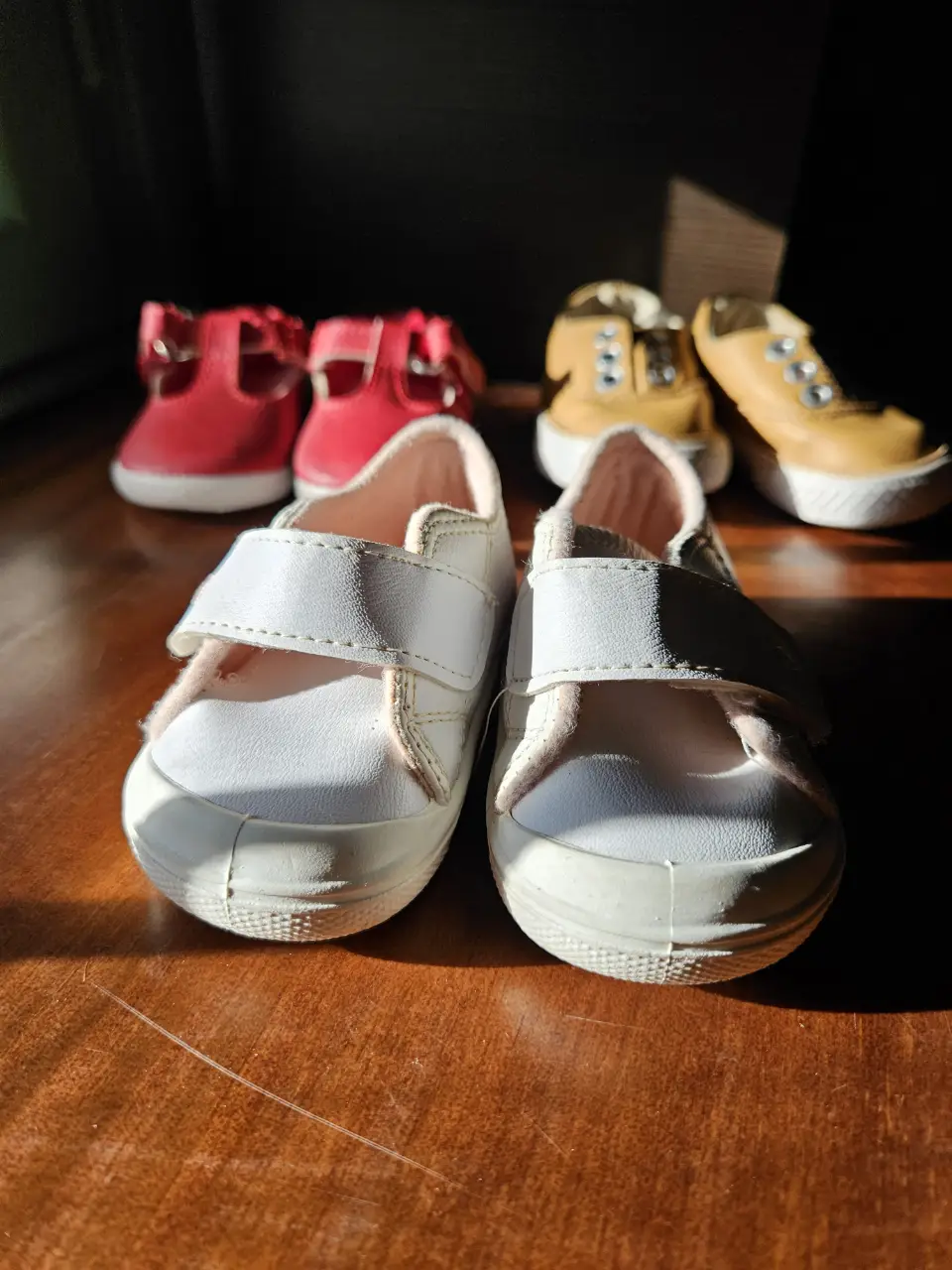 Zapatillas blancas para niña con cierre de velcro y detalles en rosa. Ideales para el día a día.
