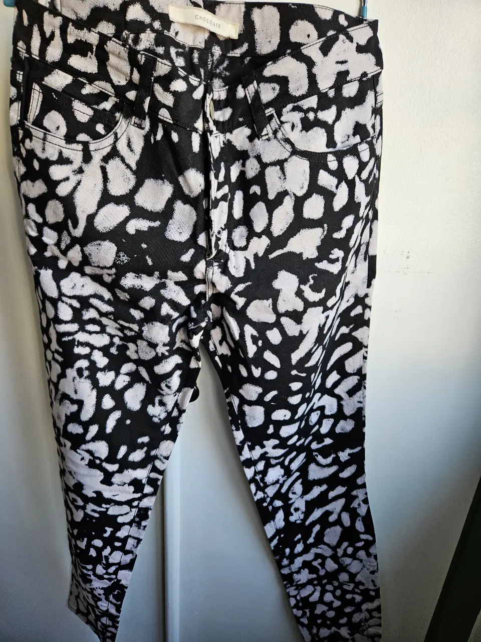 Jeans rectos de mujer con estampado abstracto en blanco y negro. Talle 42, con etiqueta de la marca Chocolate.