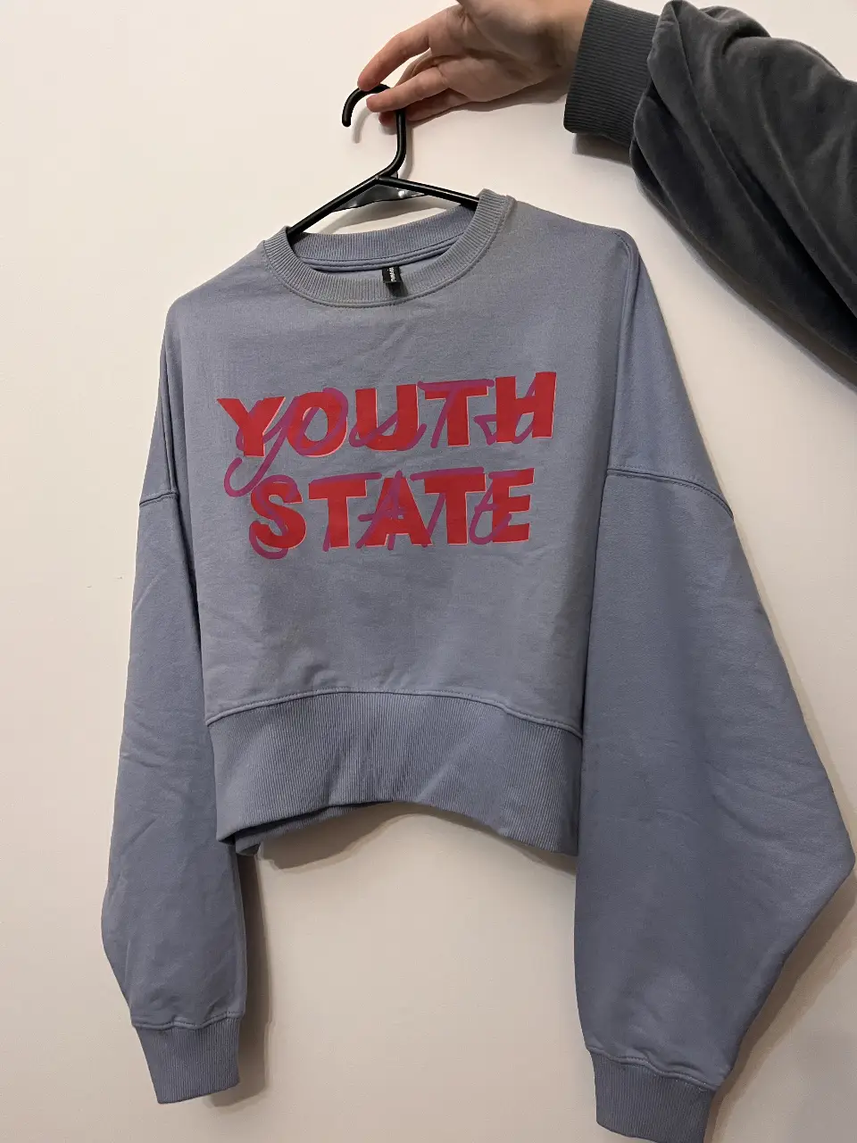 Buzo de cuello redondo celeste con estampado "YOUTH STATE" en rojo. Ideal para un look casual y moderno.