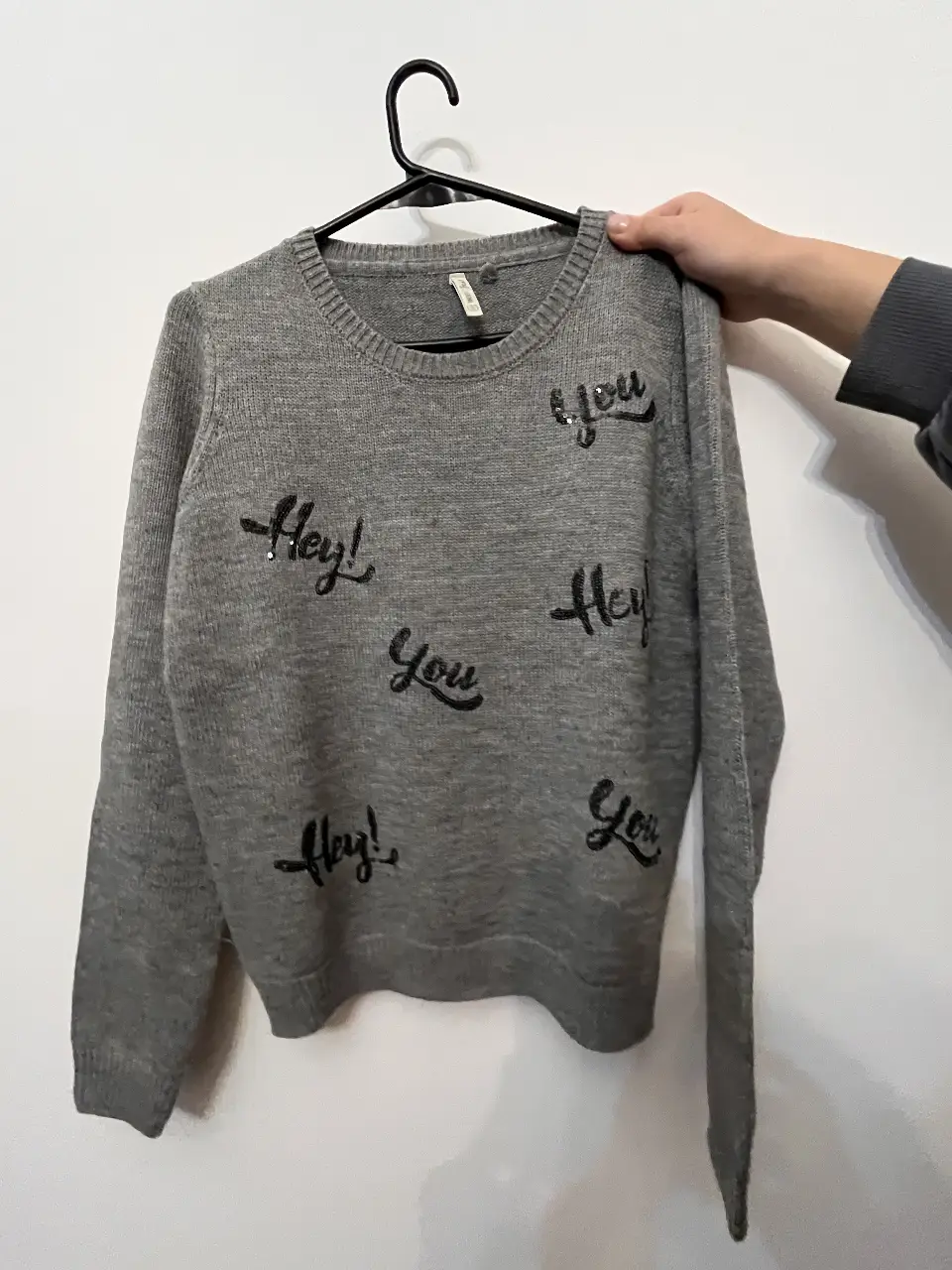 Sweater gris con detalles de "Hey!" y "You" en negro. Ideal para un look casual y cómodo. Index. sin uso