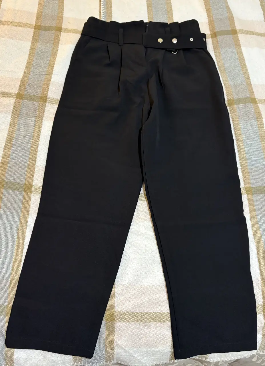 Pantalón sastrero negro, con cintura alta y detalle de cinturón con hebilla. Ideal para un look elegante y sofisticado.