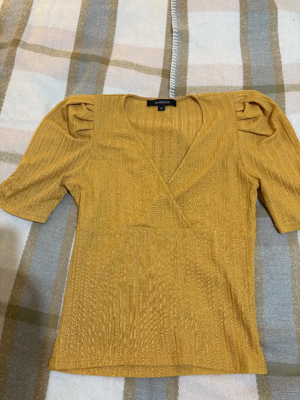 Blusa amarilla de Markova, con mangas cortas abullonadas y escote en V. Ideal para un look casual y elegante.