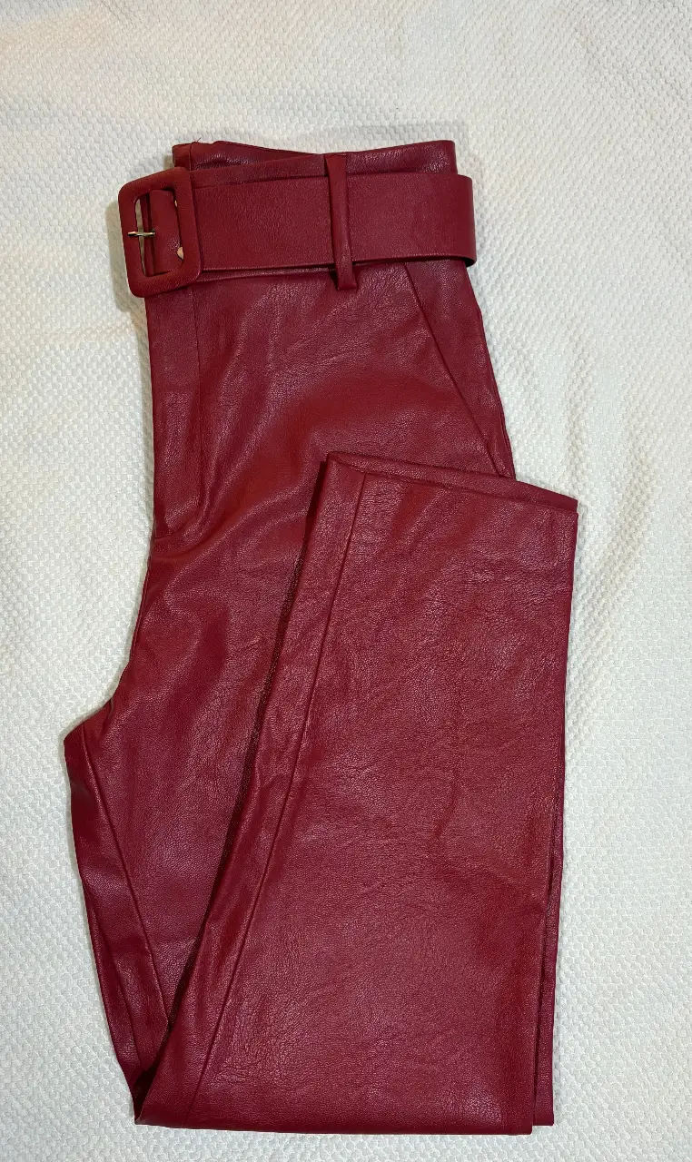 Pantalón sastrero de cuero sintético rojo con cinturón a juego. Ideal para un look elegante y moderno.