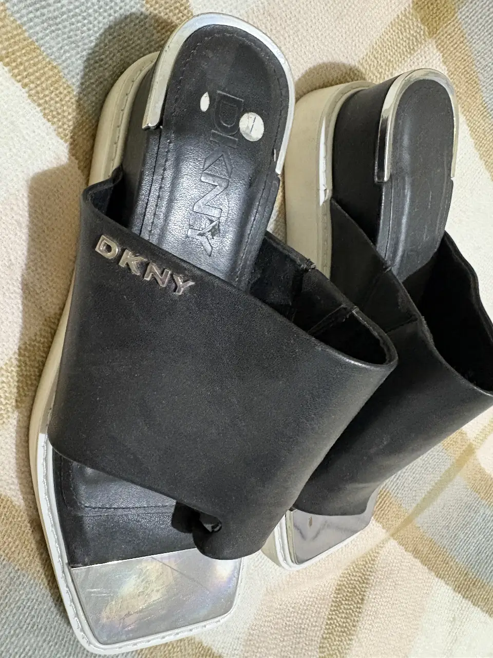 Sandalias DKNY negras con detalles plateados. Ideales para un look casual y moderno.