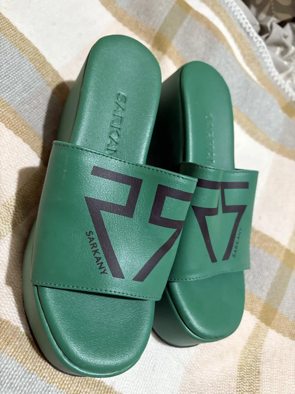 Sandalias de plataforma verdes con el número 25 estampado en negro. Marca Sarkany.