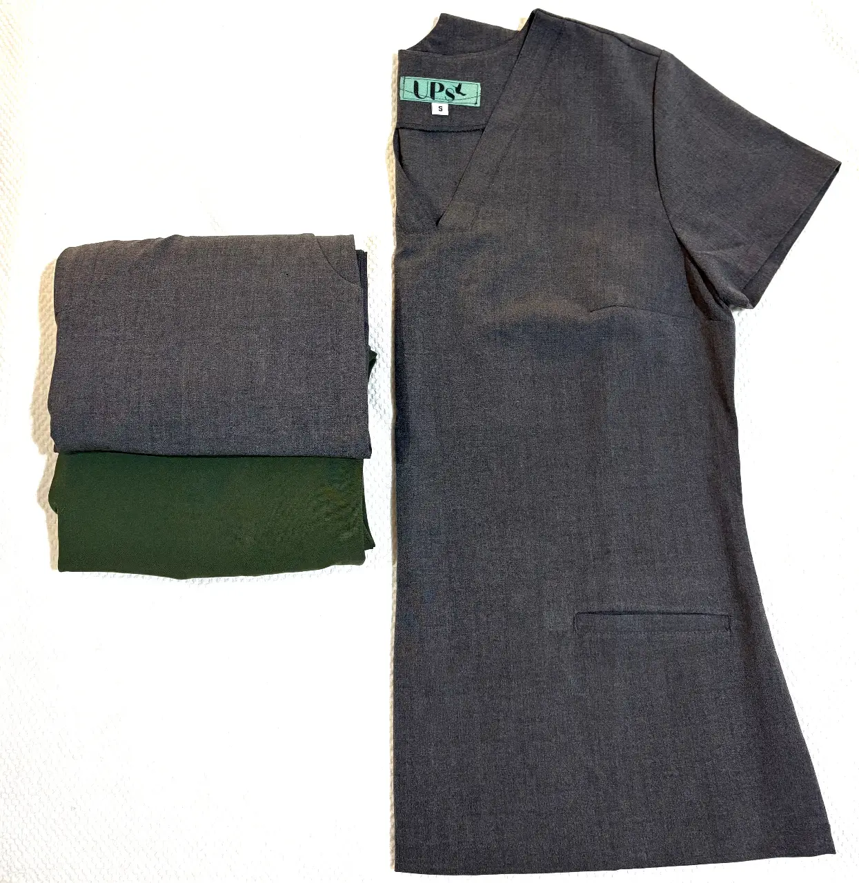 Conjunto de uniforme UPS, incluye remera con cuello en V y bolsillo, y pantalón. Ideal para profesionales de la salud.
